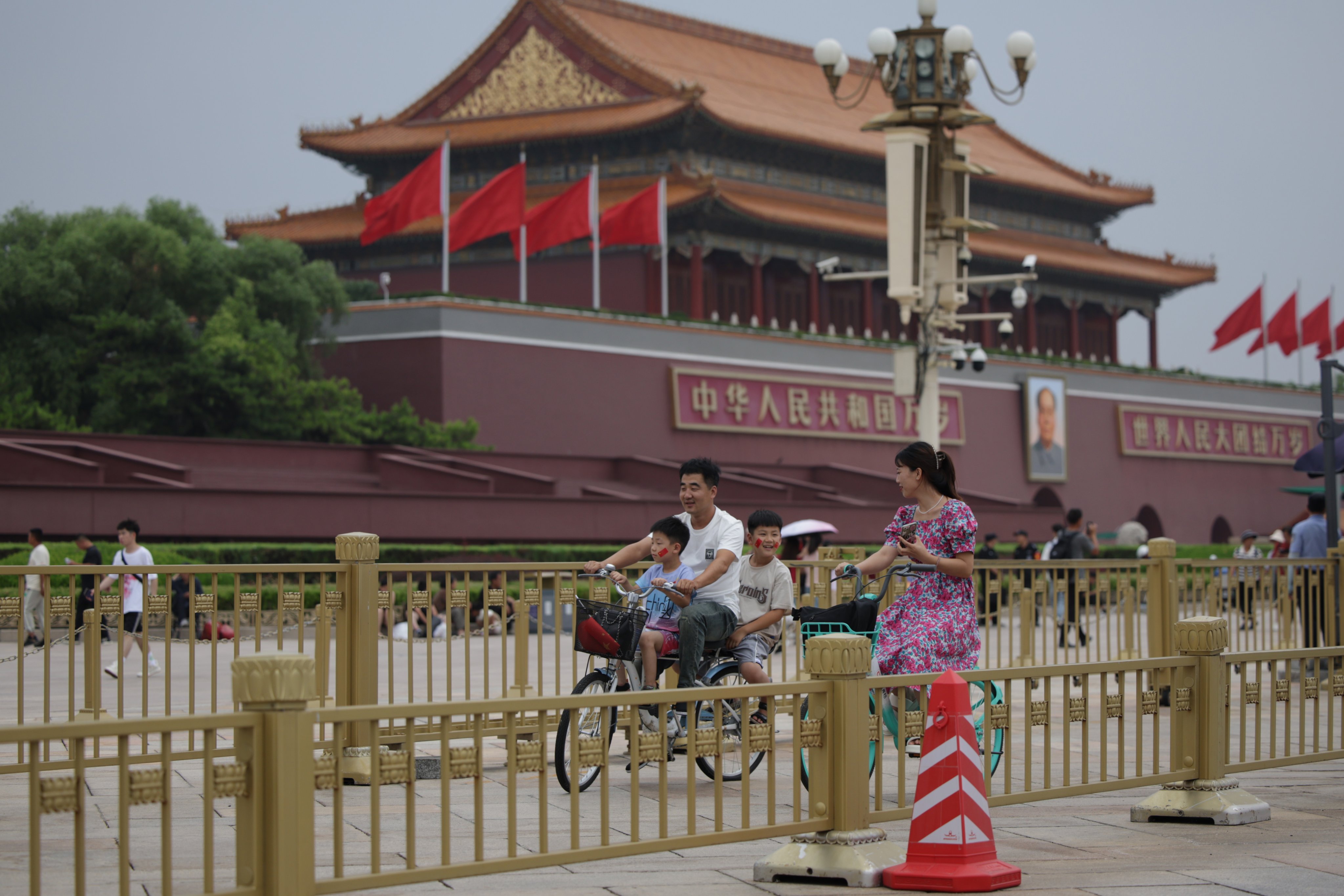 People cycle near Tiananmen Square as China’s Communist Party holds its third plenum in Beijing, China. Photo:  EPA-EFE