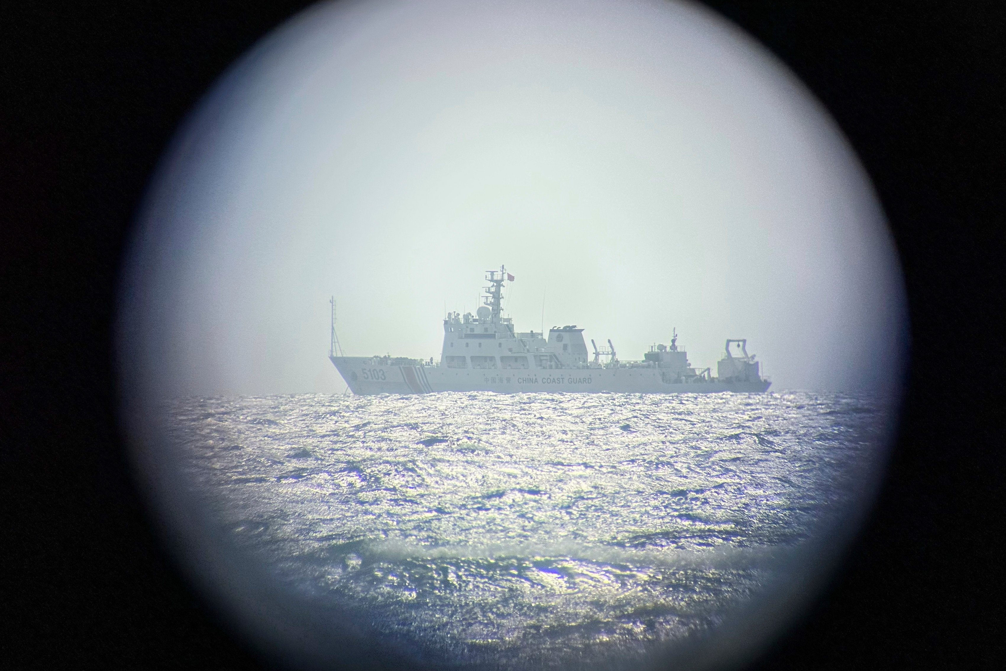 A Chinese vessel is seen through binoculars from a Philippine-occupied island in the South China Sea on Wednesday. Photo: AP
