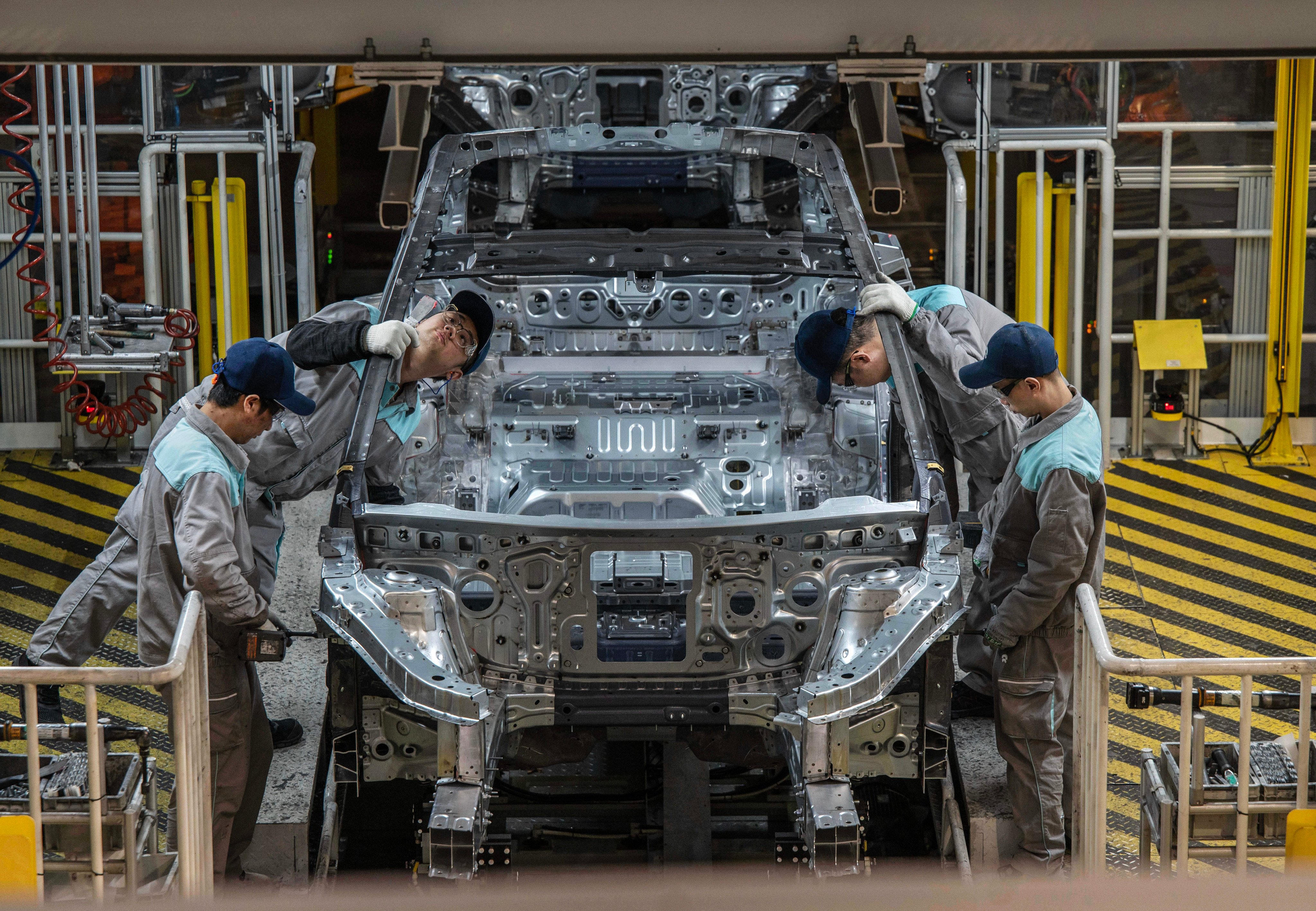 Nio workers inspect a vehicle chassis on an automated production line in Hefei, China, on January 17. Photo: Getty Images
